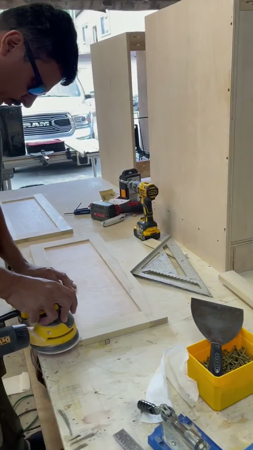 Cabinet maker sanding a custom door in the workshop